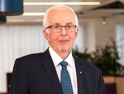 A man wearing glasses in a suit.